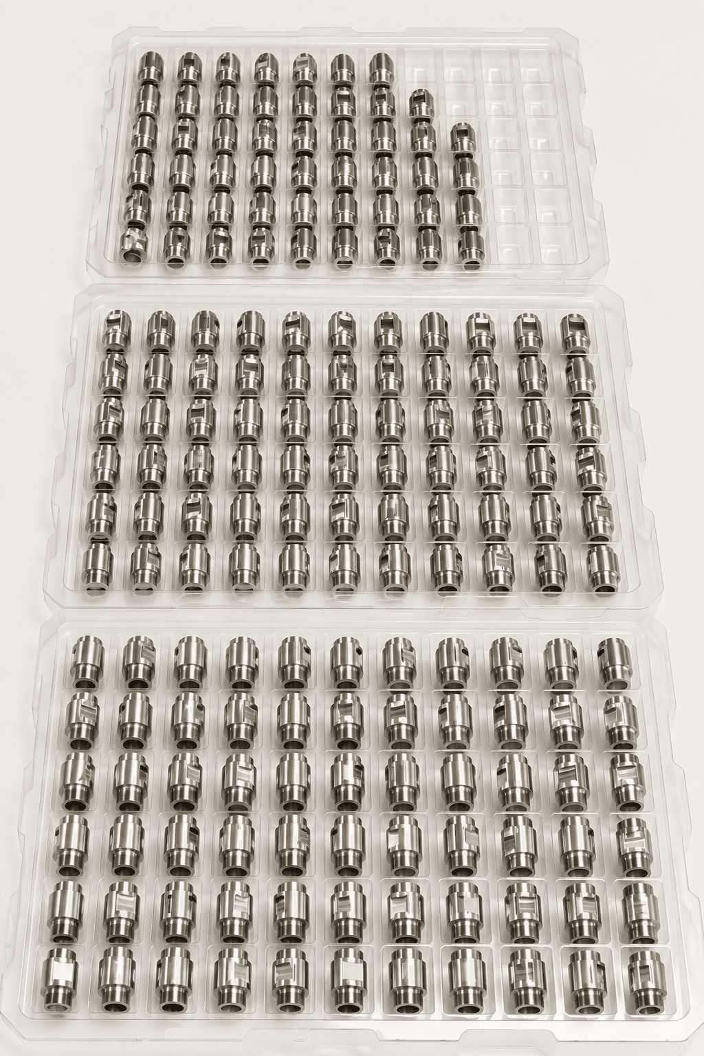 Batch of precision machined components in protective trays